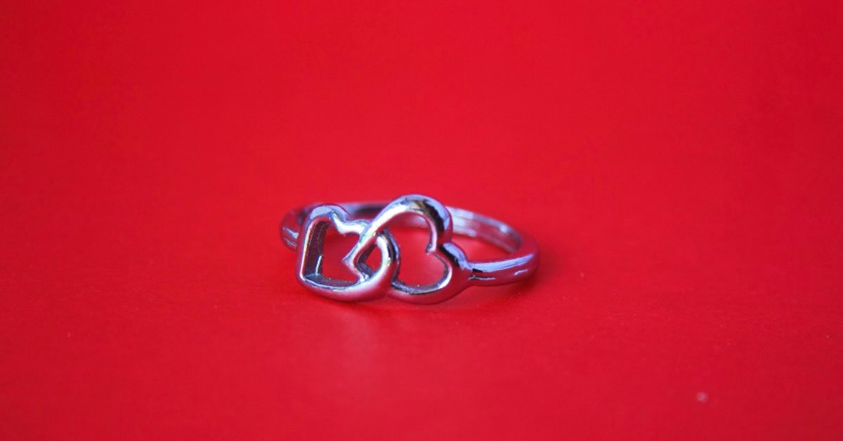 due anelli a forma di cuore su sfondo rosso